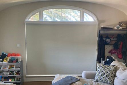 Living room window in Oakland with blackout roller shades fully closed, providing maximum privacy and light control.